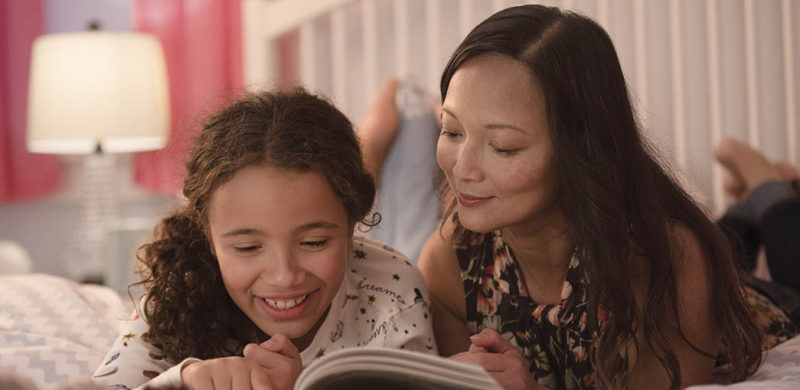 Mother reading story to daughter