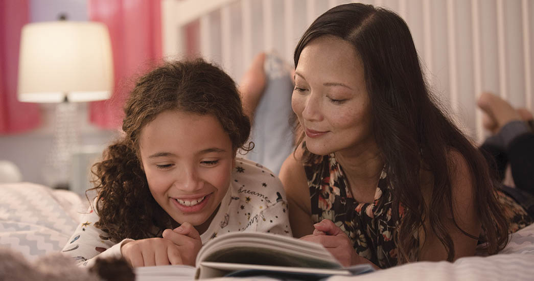 Mother reading story to daughter