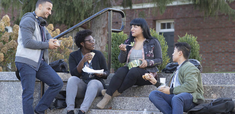 Co-workers eating lunch outside on a staircase