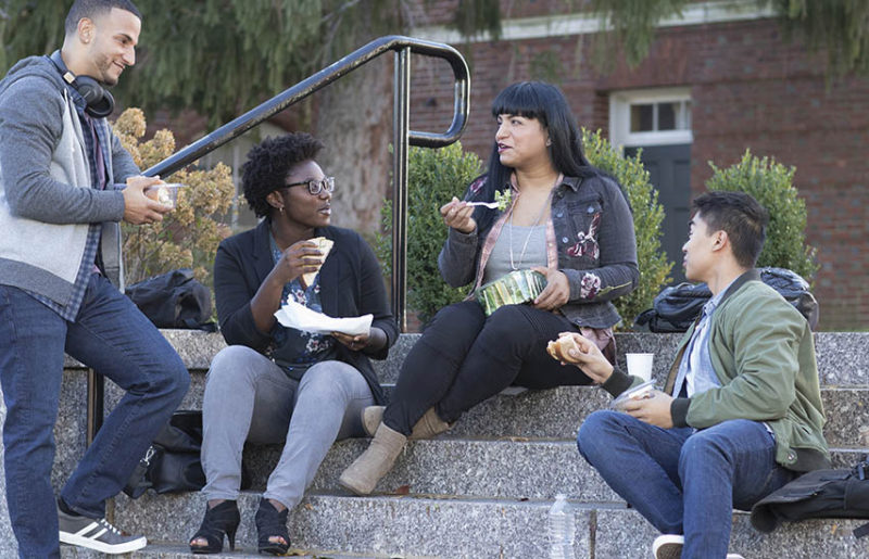 Co-workers eating lunch outside on a staircase