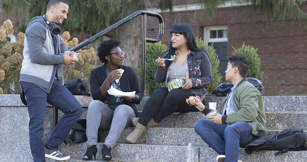 Co-workers eating lunch outside on a staircase